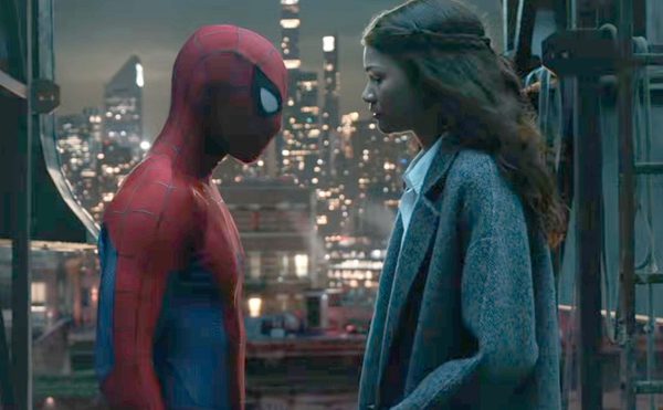 Spider man stands opposite MJ, its night time, the lights of buildings in New York can be seen in the background